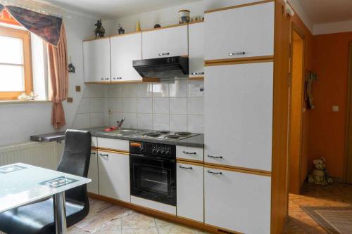 a kitchen with white cabinets and a stove top oven at Ferienwohnung Hofer in Spalt
