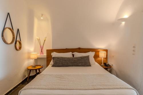 a bedroom with a large bed with white walls at Aroma Suites in Fira