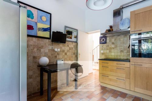 - une cuisine avec une table noire dans une pièce dans l'établissement Maison avec clim, jardin et parking Aiguelongue, à Montpellier