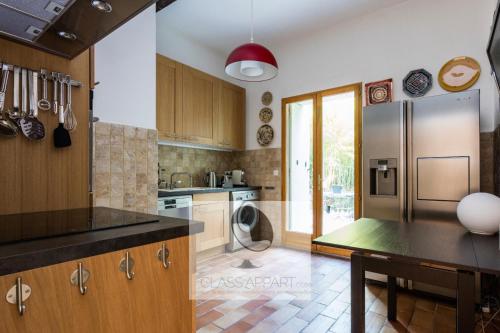 une cuisine avec un réfrigérateur et une table à l'intérieur dans l'établissement Maison avec clim, jardin et parking Aiguelongue, à Montpellier