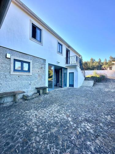 a building with a stone driveway in front of it at Casa da Ribeira - Arouca in Lázaro