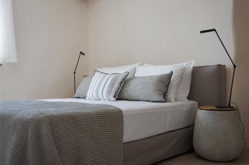 a bedroom with a bed with white sheets and pillows at Morfes Luxury Apartments in Triandáros