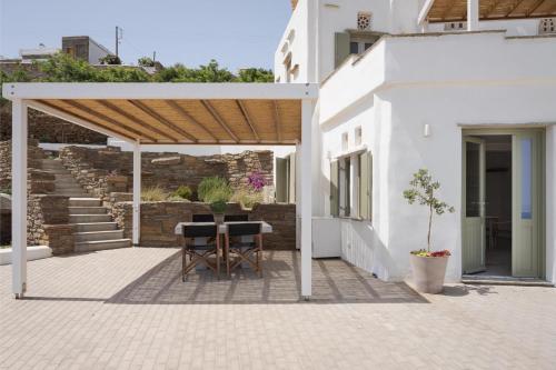 a patio with a table and chairs under a pavilion at Morfes Luxury Apartments in Triandáros