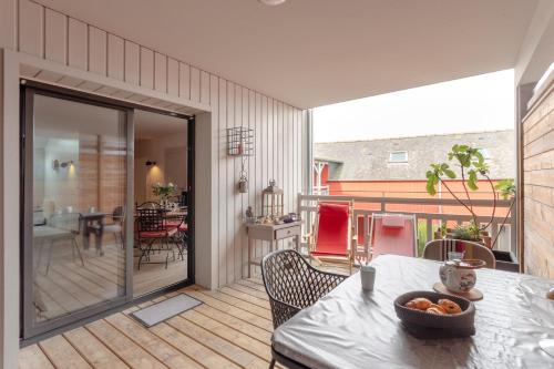 une cuisine et une salle à manger avec une table sur un patio dans l'établissement Le Deck'O - Appt dans l'hypercentre de Dinard, à Dinard