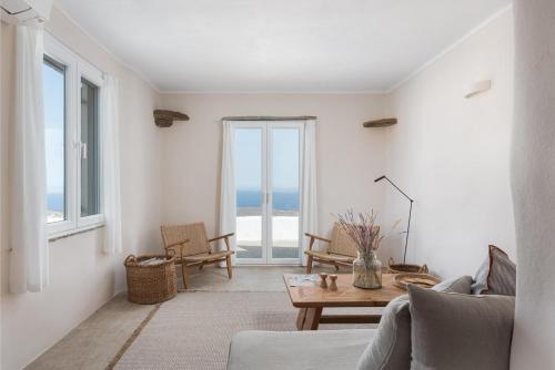 a living room with a table and a view of the ocean at Morfes Luxury Apartments in Triandáros
