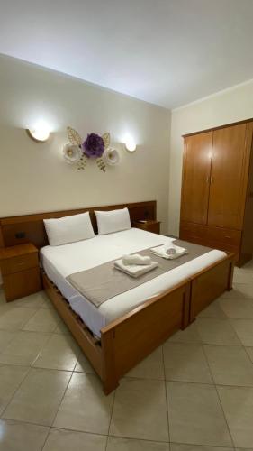 a bedroom with a large bed with two towels on it at Relax Apartment & Hotel in Golem