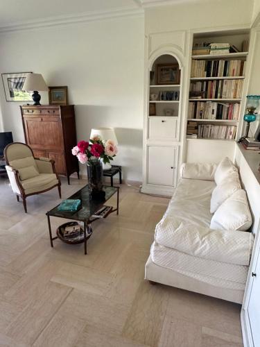 un salon avec un canapé et une table avec des fleurs dans l'établissement Cannes, à Cannes