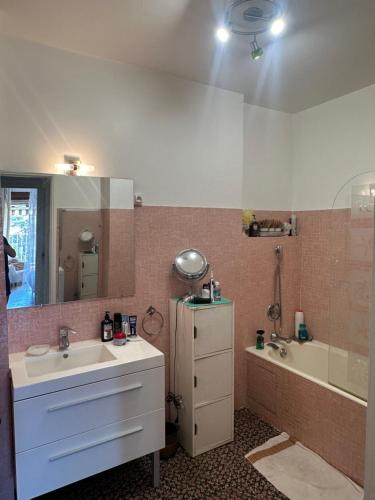 une salle de bain avec un lavabo, une baignoire et un miroir dans l'établissement Cannes, à Cannes
