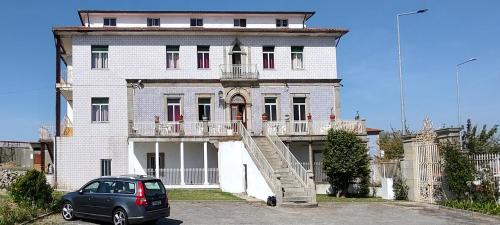 a car parked in front of a large house at Catavento Turístico in Feiteira de Dentro