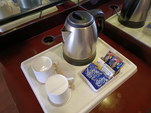 a tea pot and two cups on a tray at Vesta Maurya Palace in Jaipur