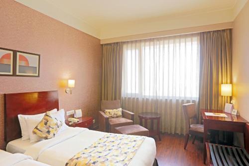 a hotel room with a bed and a desk at Vesta Maurya Palace in Jaipur