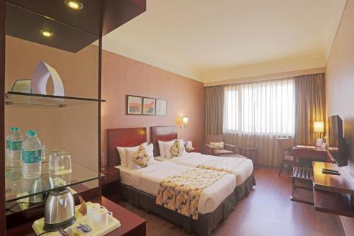 a hotel room with a bed and a desk at Vesta Maurya Palace in Jaipur