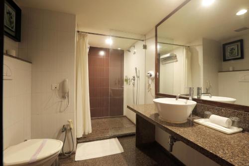 a bathroom with a sink and a toilet and a shower at Vesta Maurya Palace in Jaipur