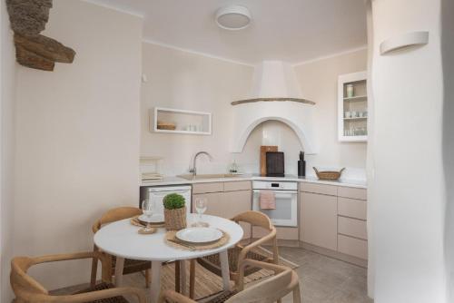 a kitchen with a white table and chairs at Morfes Luxury Apartments in Triandáros
