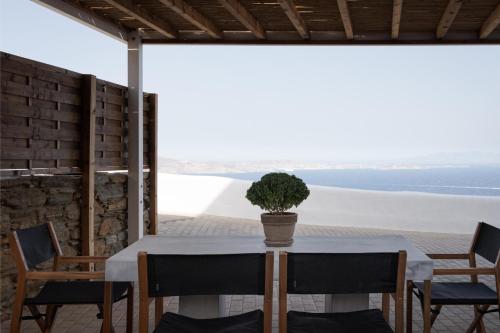 a table with chairs and a potted plant on a patio at Morfes Luxury Apartments in Triandáros