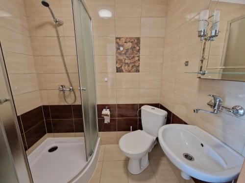 a bathroom with a toilet and a sink and a shower at Emides in Pobierowo