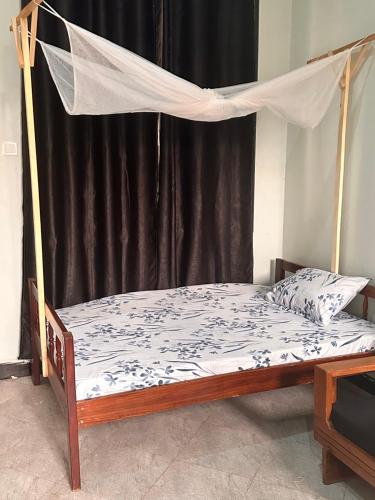 a bed with a mosquito net in a room at Pearls Homes in Moshi