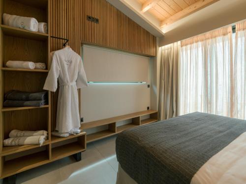 a bedroom with a bed and a dress on a shelf at Anadeo Villas & Suites in Exanthia