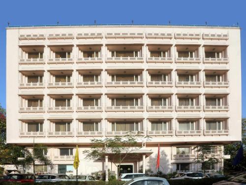 a large white building with cars parked in front of it at Vesta Maurya Palace in Jaipur
