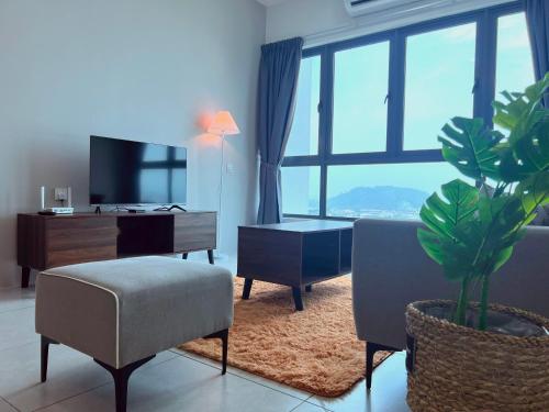 a living room with a tv and a couch and a plant at Meritus - Perai, Penang in Perai
