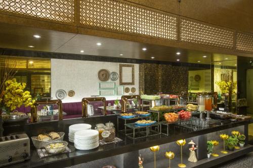a buffet line with food on display in a restaurant at Vesta Maurya Palace in Jaipur