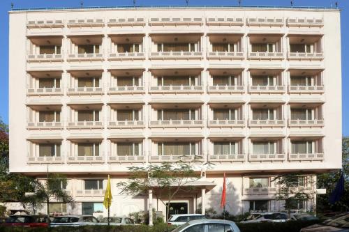 a large white building with cars parked in front of it at Vesta Maurya Palace in Jaipur