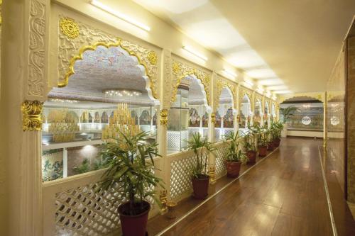 a hallway with potted plants on the wall at Vesta Maurya Palace in Jaipur