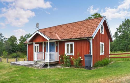 a red tiny house with a porch at Pet Friendly Home In Fröseke With Sauna in Fröseke