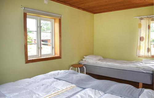 two beds in a room with a window at Pet Friendly Home In Fröseke With Sauna in Fröseke