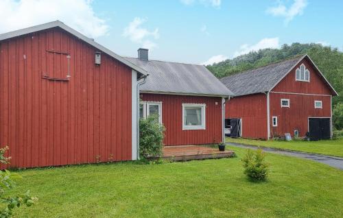 a couple of red barns in a yard at 2 Bedroom Cozy Home In Falköping in Falköping