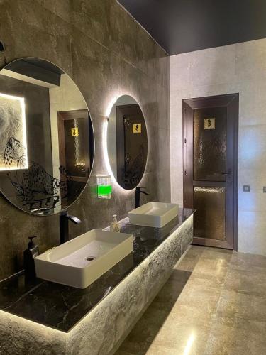a bathroom with two sinks and a large mirror at Irbis Hostel in Karakol