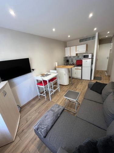 un salon avec un canapé et une cuisine dans l'établissement T2 Berck-plage, à Berck-sur-Mer