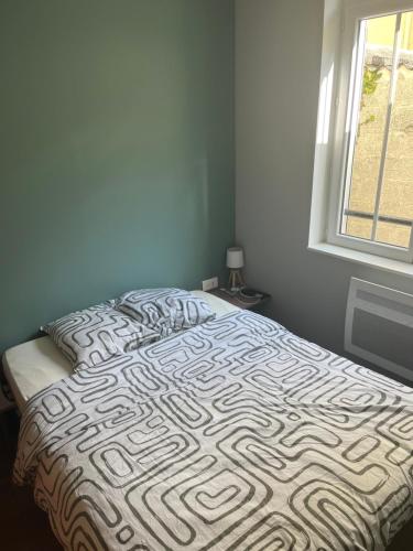 - un lit dans une chambre à côté d'une fenêtre dans l'établissement T2 Berck-plage, à Berck-sur-Mer