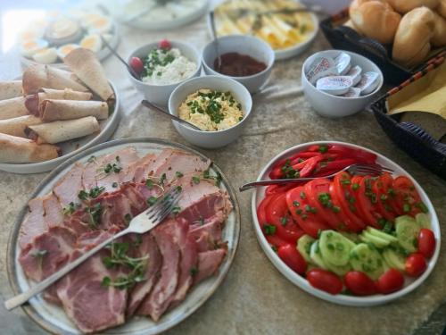 Dom w Janowcu z widokiem na zamek - blisko Magiczne Ogrody في جانوويك: طاولة مليئة بأطباق الطعام مع اللحوم والخضروات