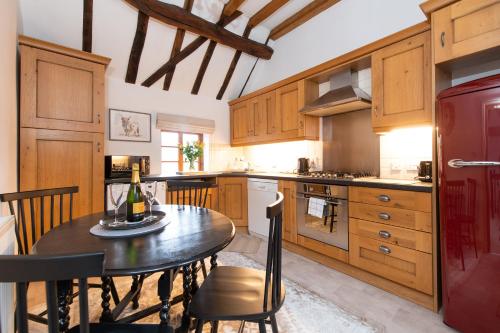 a kitchen with a table with a bottle of wine on it at Hideaway Cottage Bewdley with parking near the River Severn in Bewdley