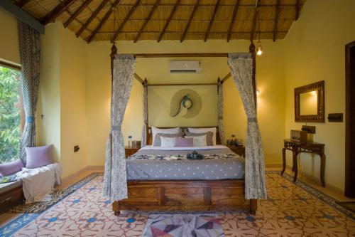 a bedroom with a bed with a canopy at Elivaas 5 BHK with Pool, Tents & Pond - Kaimalgarh Farmstay in Bhundsi
