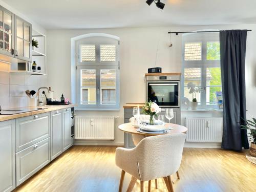 una cucina con un tavolo e sedie in una stanza di Modernes Appartement "ALTE MÄDCHENSCHULE", inkl Stellplatz, E-Bike Ladestation, Boxspringbett, Business, 2 Personen, gratis Kaffee und Tee, WLAN a Bautzen