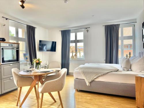 a bedroom with a bed and a table with chairs at Modernes Appartement "ALTE MÄDCHENSCHULE", inkl Stellplatz, E-Bike Ladestation, Boxspringbett, Business, 2 Personen, gratis Kaffee und Tee, WLAN in Bautzen