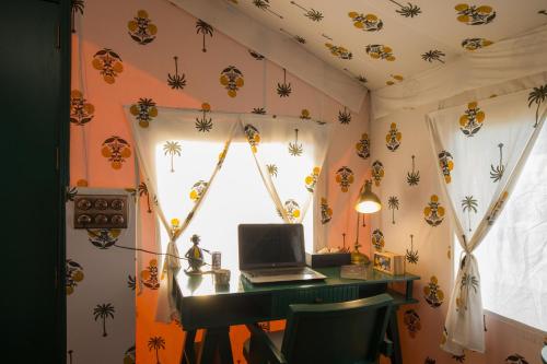 a room with a desk with a laptop and spiders on the ceiling at Elivaas 5 BHK with Pool, Tents & Pond - Kaimalgarh Farmstay in Bhundsi