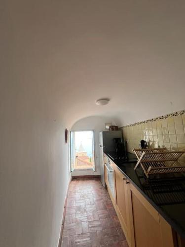 une cuisine avec un comptoir et une fenêtre dans l'établissement Appartement vue mer au cœur du vieux village, à Roquebrune-Cap-Martin