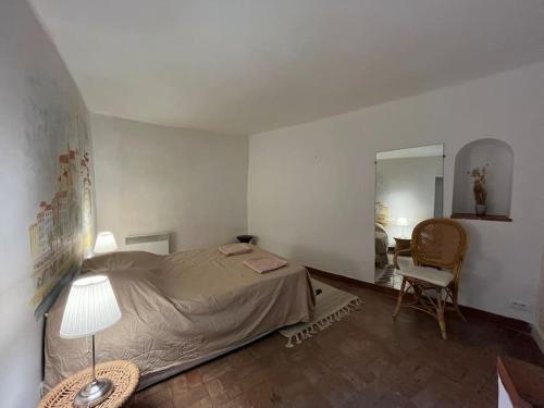 une chambre avec un lit, une table et une chaise dans l'établissement Appartement vue mer au cœur du vieux village, à Roquebrune-Cap-Martin