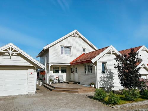 a large white house with a white garage at Newly renovated studio apartment - free parking and EV docking in Trondheim