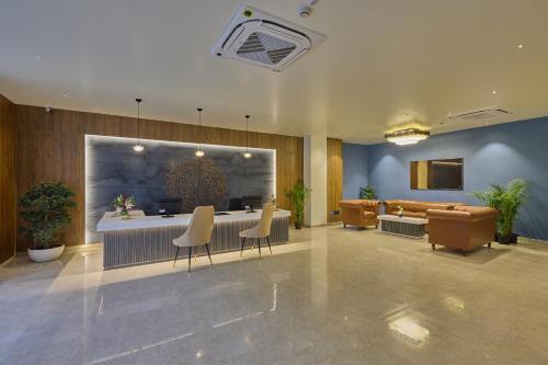 a lobby with a bar with chairs and a couch at Grand Continent Mysore A Sarovar Portico Affiliate Hotel in Mysore