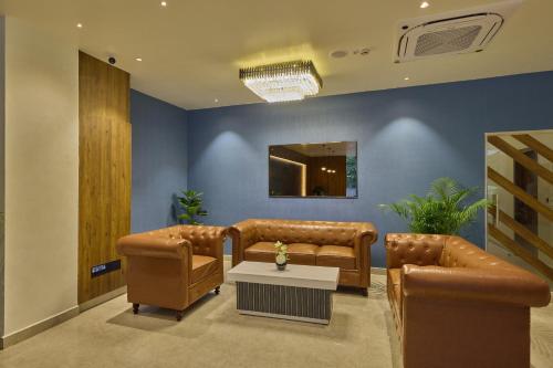 a waiting room with two leather couches and a table at Grand Continent Mysore A Sarovar Portico Affiliate Hotel in Mysore