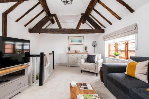 a living room with a couch and a tv at Hideaway Cottage Bewdley with parking near the River Severn in Bewdley