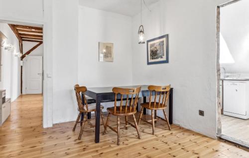 a dining room with a black table and four chairs at Ferienwohnung Daniela in Rambin