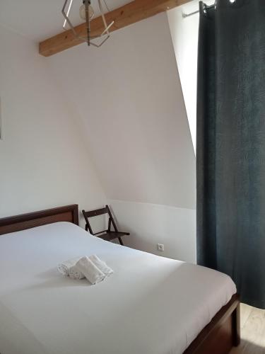 a bedroom with a white bed with a black curtain at WIFI- STADE DE FRANCE- BASILIQUE CATHEDRALE MONSEJOURASAINTDENIS in Saint-Denis