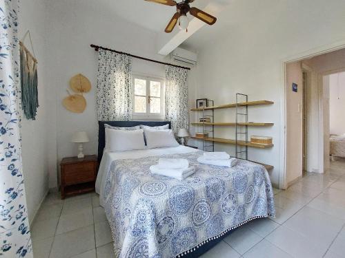 a bedroom with a bed with a blue and white blanket at Poros Pine View in Poros