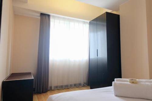 a bedroom with a bed and a large window at Best Location 2BR at Braga City Walk Apartment By Travelio in Bandung
