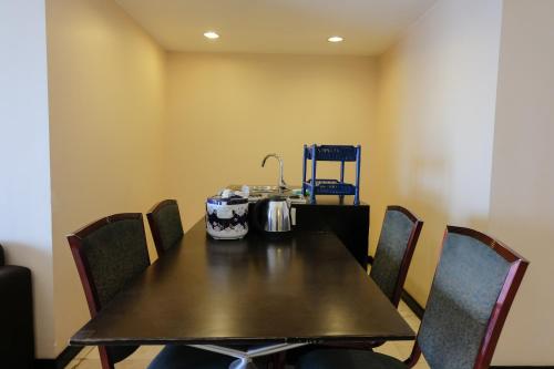 a table in a room with chairs around it at Best Location 2BR at Braga City Walk Apartment By Travelio in Bandung